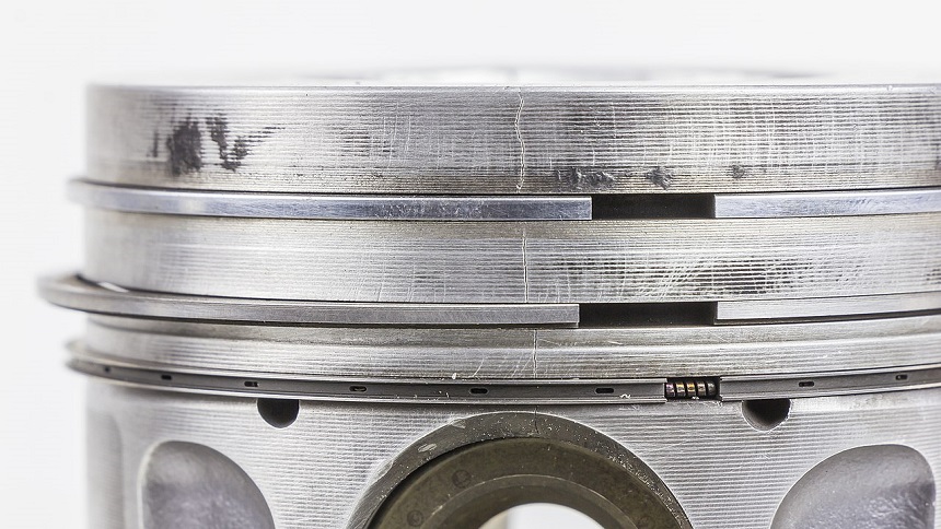 Par de segmentos montados en un pistón de 47 mm de diámetro perteneciente a un motor de ciclo de dos tiempos de una motoneta