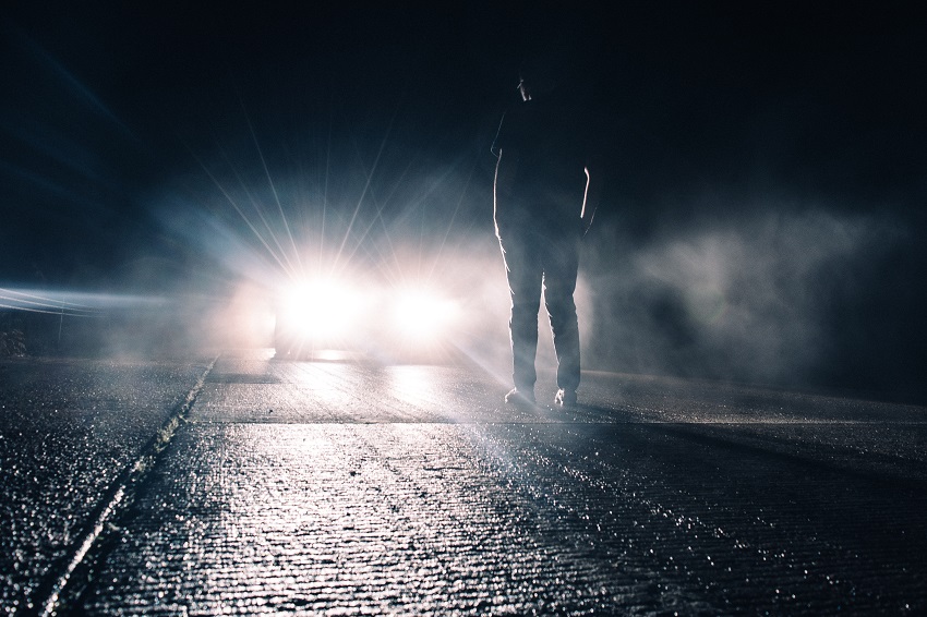 Colisiones en carretera, hombre iluminado por un auto