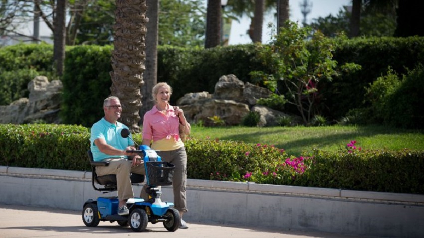 ScooterDR, uno de los ganadores del Premio Excelencias 2018, anciano sobre un ScooterDR acompañado