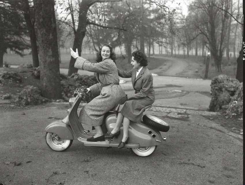 Foto antigua de dos mujeres sobre una Lambretta